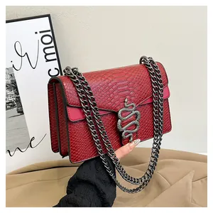 Nahaufnahme der Schultertasche mit Schlangenprägung, Schlangenkopf-Verschluss und Kette