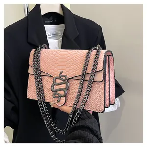 Detailansicht der rosa Umhängetasche mit Schlangenmuster und Metall-Schlangenverschluss