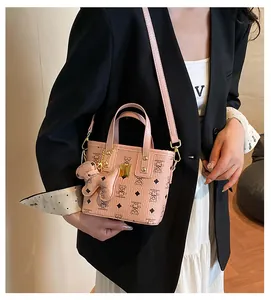 Pink mini bucket bag with cartoon bear print and bear charm on white shirt model