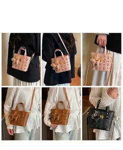 Detail of printed bucket bag with animal charm and monogram pattern displayed by model