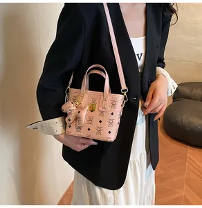 Detail of pink floral print mini bag with golden hardware and cute puppy charm