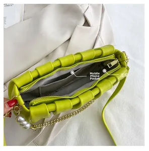 Internal view of neon green pleated handbag featuring main pocket and phone pocket