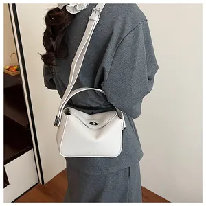 Détail du sac à main blanc en cuir grainé avec fermoir rotatif et poignée latérale
