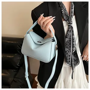 Détail de la texture cuir grainé bleu clair et du fermoir métallique sur un sac style Lindy