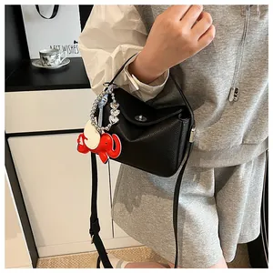 Détail du sac à main noir en cuir grainé avec fermoir argenté et breloque éléphant rouge