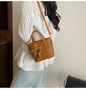 Close-up of brown bucket bag with bear patterns and a dog-shaped leather charm