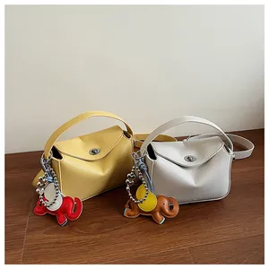Détail de sacs à bandoulière demi-lune en cuir grainé avec breloques éléphant