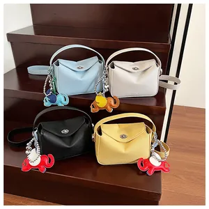 Détails de petits sacs carrés colorés avec breloques éléphant et texture cuir