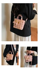 Detailed view of pink mini tote bag with bear print, metallic buckle and charm