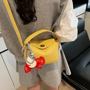 Sac croissant jaune à motif litchi avec breloque éléphant et boucle métallique