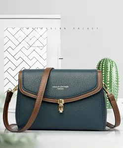 Close-up of a navy blue litchi pattern leather bag with gold metal clasp closure