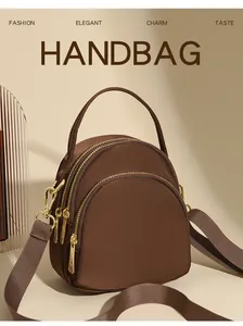 Λεπτομέρεια mini καφέ νάιλον τσάντα χιαστί με τρεις χρυσές θήκες με φερμουάρ