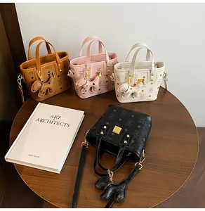 Detail view of mini printed tote bags in four colors with cute dog charms on a table