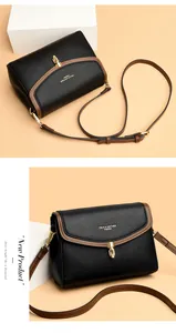 Detailed macro view of black pebble leather handbag with gold metal lock and brand logo
