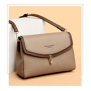 Detail of khaki pebbled leather flap bag with gold twist lock and brand logo embossing