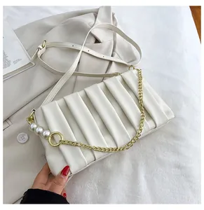 Detail of white pleated handbag with elegant pearl strap and leather shoulder strap