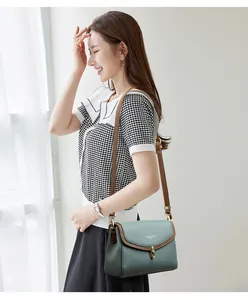 Close-up of green pebble leather bag with gold twist lock and brown trim details