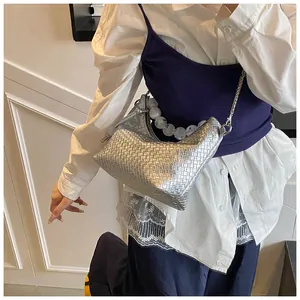 Détail du sac hobo tressé argenté avec poignée en perles et fine bandoulière en chaîne métal
