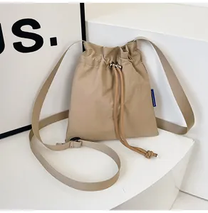 Détail du sac seau en nylon kaki avec cordon de serrage et boucle de réglage en métal