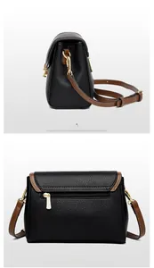 Detail view of black pebble leather crossbody bag with brown trim and gold hardware