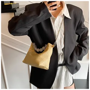 Détail du sac sous le bras jaune avec poignée en perles et chaîne argentée chic