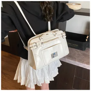 Close-up of a white leather vintage style tote bag with silver hardware on a model