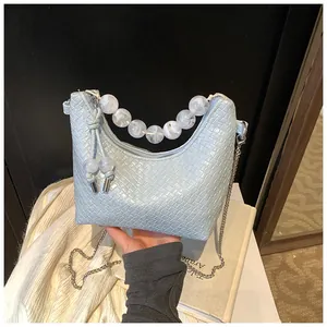 Détail du sac hobo bleu clair à motif croco avec anse en perles de marbre blanc