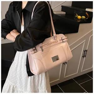 Detail of the light pink tote bag featuring glossy faux leather and side buckle straps