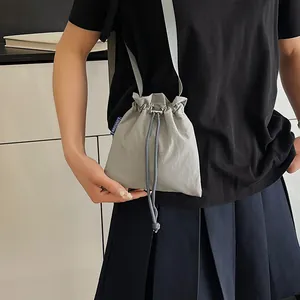 Sac seau en nylon gris imperméable à cordon coulissant porté par un mannequin