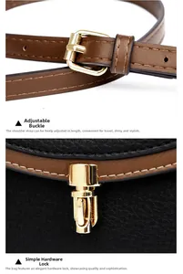 Close-up of golden metal buckle and clasp on black lychee grain leather crossbody bag