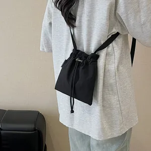 Sac seau bandoulière en nylon noir imperméable avec cordon de serrage et design plissé