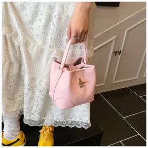 Detail of pink lychee textured bucket bag with gold metal twist lock and sturdy handle