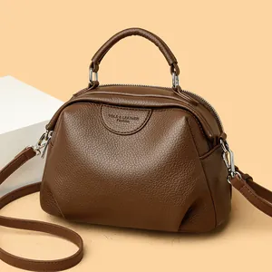 Modische dunkelbraune Handtasche aus Kieselleder mit Rundgriff und Umhängeriemen