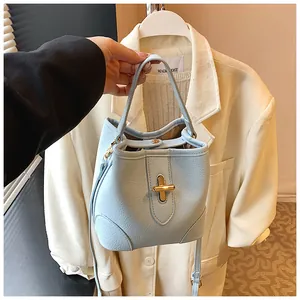 Detail of light blue bucket bag with pebble texture and gold twist lock closure