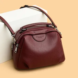 Burgunderfarbene Handtasche aus Leder mit Schultergurt und silbernen Metallreißverschlüssen