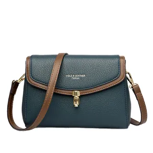 Fashionable dark teal lychee grain leather crossbody bag with brown trim and gold lock