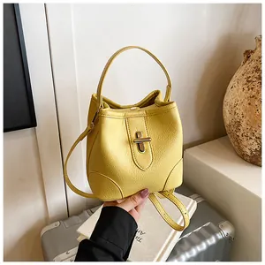 Top-down view of yellow lychee grain leather bucket bag with golden twist lock detail