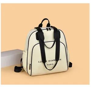 Detailaufnahme des cremefarbenen Rucksacks mit schwarzen Riemen und Lucky Diamond Paris Text