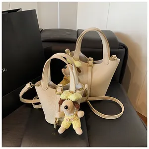 Detail view of lychee pattern leather bucket bags with luxury gold hardware and charms