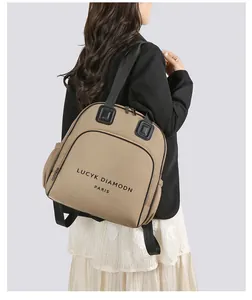 Detailansicht des khakifarbenen Rucksacks mit schwarzem Logo und praktischen Seitentaschen