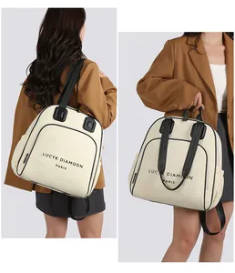 Detail des cremefarbenen Rucksacks mit minimalistischem Pariser Schriftzug und Trägern