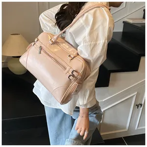 Detail of light pink faux leather tote bag with metallic studs and front zipper compartment