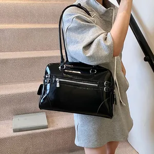 Large black patent leather tote bag with glossy finish and silver buckle accents