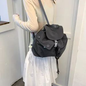 Mochila minimalista de nailon gris oscuro con cordón y hebilla para uso diario casual