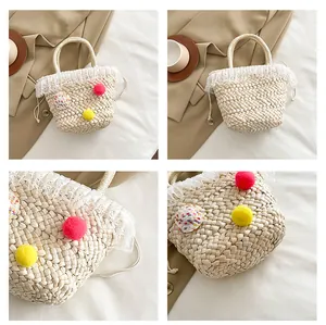 Detailopnames van handgemaakte strooien handtas met kant en kleurrijke pompons voor zomer