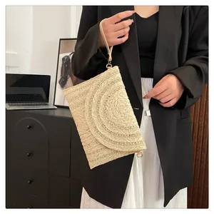Stylish bohemian straw woven envelope clutch bag shown in a professional lifestyle setting