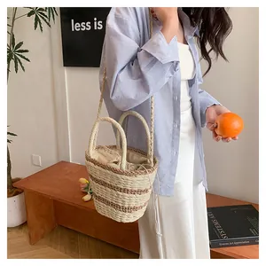 Mannequin portant un sac seau tissé beige avec cordon de serrage dans un cadre cosy