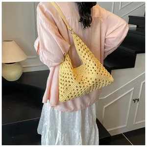 Close-up of hollow crochet texture and metallic ring detail on yellow woven tote bag