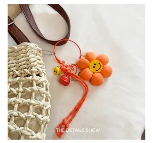 Detailopname van oranje pluche zonnebloem tashanger met smiley en gekleurde belletjes