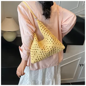 Detail of hand-woven hollow straw shoulder bag with mesh texture for beach holidays